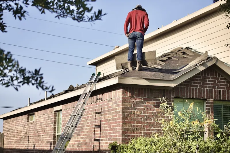 Professional roofer working on a residential roof in West Hempstead